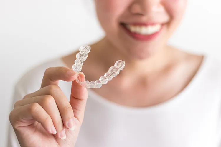 Person holding a pair of invisalign aligners - Harmony Family Dentistry in Vancouver WA
