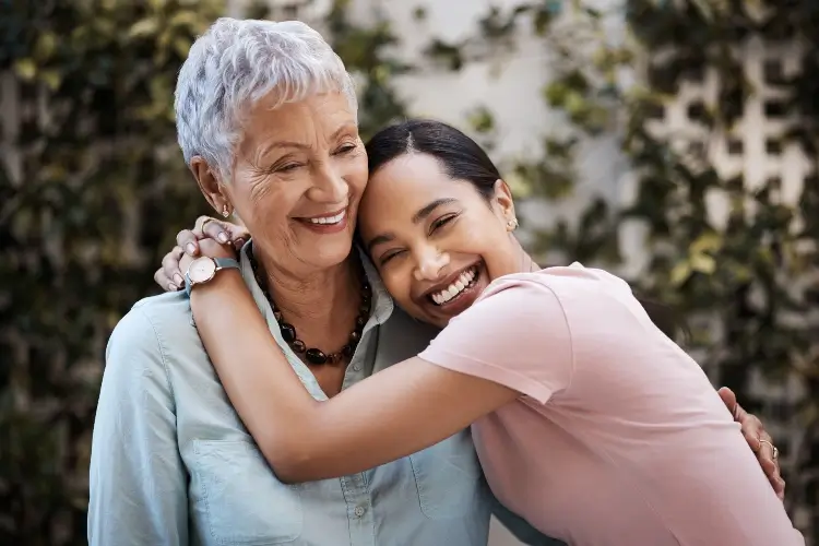 women smile happily as she reflects on how long bioclear treatment lasts on teeth - 10 years