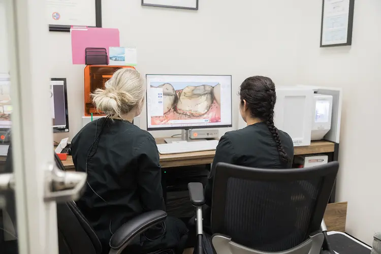 Harmony Family Dentistry hygienist and assistant looking at a digital mouth rendering