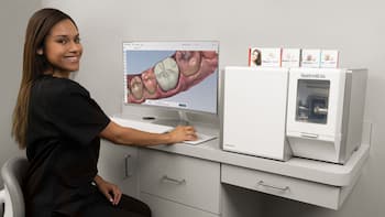 Dentist in front of a dental milling machine