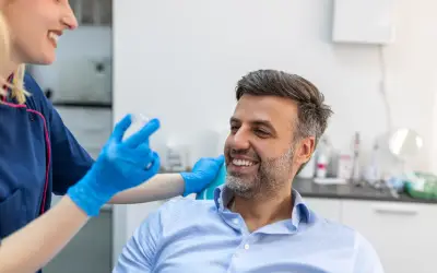 man receiving invisalign aligner as adult tooth straightening treatment